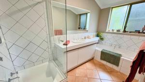 a bathroom with a shower and a sink at Coastal Haven on Sandpiper in Broadwater +23 photos