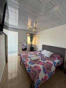 a bedroom with a bed with a colorful bedspread at Hotel Sol del Magdalena in La Dorada