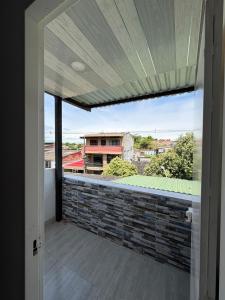 an open door to a balcony with a view of a building at Hotel Sol del Magdalena in La Dorada