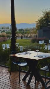 a wooden table with wine glasses on a deck at Amerian Chacras de Coria in Chacras de Coria