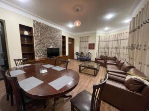 a living room with a table and a couch at Heritage Cottage Kashmir Point in Murree