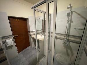 a bathroom with a glass shower and a sink at Heritage Cottage Kashmir Point in Murree