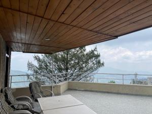 a balcony with a table and chairs and a view at Heritage Cottage Kashmir Point in Murree