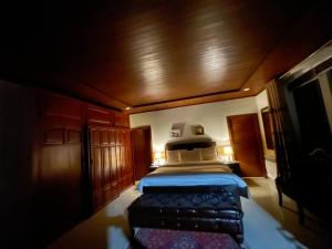 a bedroom with a bed in a room with wooden walls at Heritage Cottage Kashmir Point in Murree