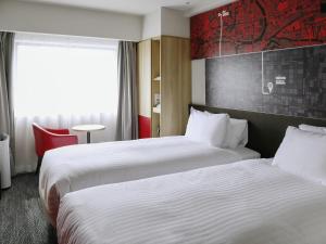 a hotel room with two beds and a window at ibis Osaka Umeda in Osaka