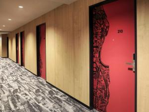 a row of doors in a hallway with red walls at ibis Osaka Umeda in Osaka