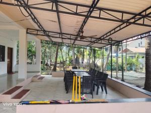 a dining area with a table and chairs and windows at Taksh Stay in Nagaon