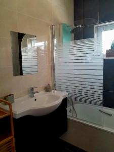 a bathroom with a sink and a tub and a mirror at AuraHouse Algarve in Lagoa +4 photos