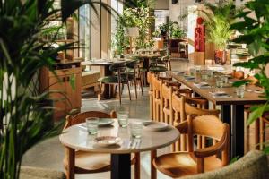 a restaurant with tables and chairs and plants at Locke Copenhagen in Copenhagen