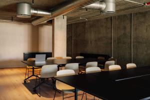 a conference room with tables and chairs and a laptop at Locke Copenhagen in Copenhagen