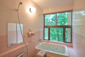 a bathroom with a bath tub and a window at Wolke Lodge in Shinano +41 photos