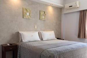 a bedroom with a bed and two pictures on the wall at Hotel Termal Emperatriz Termas de Río Hondo in Termas de Río Hondo