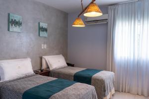 a hotel room with two beds and a window at Hotel Termal Emperatriz Termas de Río Hondo in Termas de Río Hondo