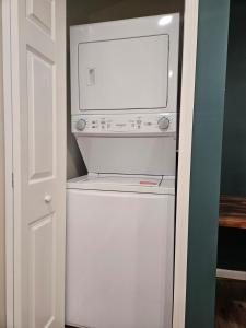 a microwave sitting on top of a white refrigerator at Tiny Home with Grill Laundry Deck Desk in Phenix City