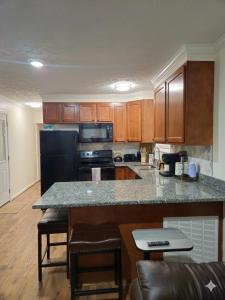 a kitchen with a black refrigerator and a counter top at Tiny Home with Grill Laundry Deck Desk in Phenix City