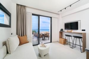 a living room with a couch and a table with chairs at Ethos Zeen Private Pool Suites in Potamiá