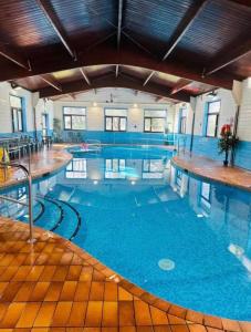 a large indoor swimming pool with blue water at 47 Trevithick Court in Hayle