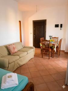 a living room with a couch and a table and chairs at Apartments Vila Cala in Durrës