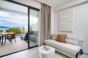a living room with a couch and a view of the ocean at Ethos Zeen Private Pool Suites in Potamiá