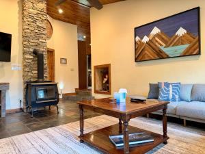 a living room with a couch a table and a fireplace at Bearadise by Casago McCall - Donerightmanagement in McCall