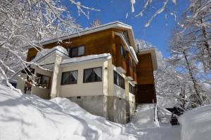 a house covered in snow in the snow at Wolke Lodge in Shinano