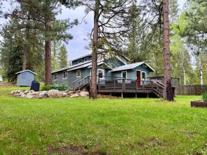 a blue house with a porch and a yard at Bearadise by Casago McCall - Donerightmanagement in McCall