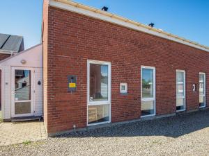 a red brick building with windows on the side at 6 person holiday home in Rømø-By Traum in Sønderby