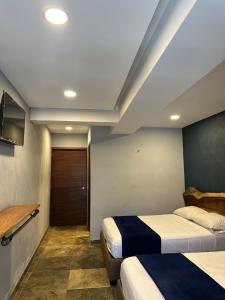 a room with two beds and a television in it at Hotel La Bikina in Tequila