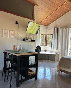 a room with a desk with a bed and a window at Chalé Lumiar in Santana do Riacho