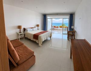 a bedroom with a bed and a couch and a table at Hotel Punta Blanca - Jama - Manabí in Jama