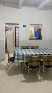 a dining room table with chairs and a blue and white checkered table at Pousada Recanto Bella Vista in Saubara