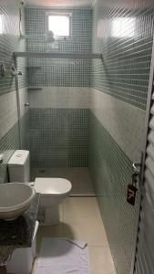 a green tiled bathroom with a toilet and a sink at Pousada Recanto Bella Vista in Saubara +22 photos
