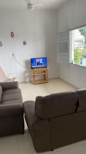 a living room with a couch and a flat screen tv at Pousada Recanto Bella Vista in Saubara