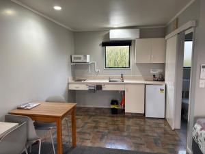 a small kitchen with a table and a sink at Commodore Court Motel in Blenheim