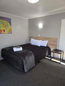 a bedroom with a large bed in a room at Commodore Court Motel in Blenheim +91 photos