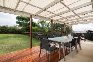 a patio with a table and chairs on a deck at Rundle & Salt in Ulladulla