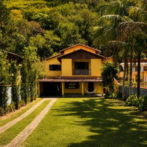a yellow house with a lush green yard at Areal in Areal