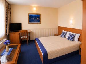 a hotel room with a bed and a television at Hotel Rostov in Pleven