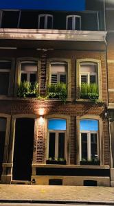 a brick building with windows and plants on it at La Muse Ment - Suite La Valtesse de la Bigne in Liège