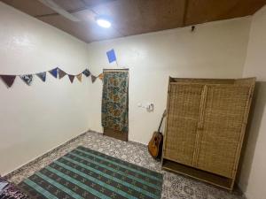 a room with a door and a rug and a guitar at Marysa Lodge in Kotu +24 photos