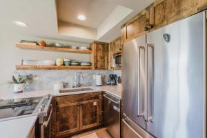a kitchen with wooden cabinets and a stainless steel refrigerator at Lakeview Meadow Retreat in Sisters +17 photos