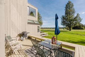 a patio with a table and a blue umbrella at Lakeview Meadow Retreat in Sisters