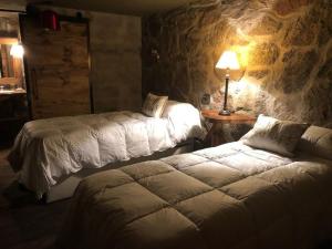 a bedroom with two beds and a table with a lamp at Huellas de Berna in Villa Berna