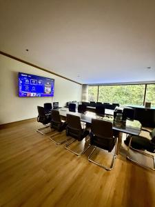 a conference room with chairs and a large screen at Casa Bosques in Mexico City +33 photos