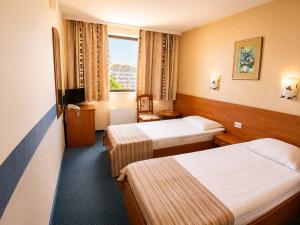 a hotel room with two beds and a television at Hotel Rostov in Pleven +47 photos