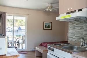 a kitchen with a sink and a stove top oven at Motel de l'Anse a l'Eau in Tadoussac +53 photos