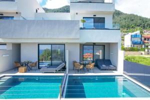 a villa with a swimming pool and a house at Ethos Zeen Private Pool Suites in Potamiá