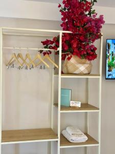 a white closet with a vase of red flowers at Hotel Imperial in Dhërmi +89 photos