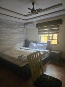 a bedroom with a bed and a ceiling fan at The Maison Lodge in Ijegun