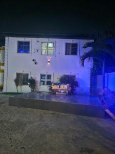 a white house with a couch in front of it at The Maison Lodge in Ijegun +25 photos